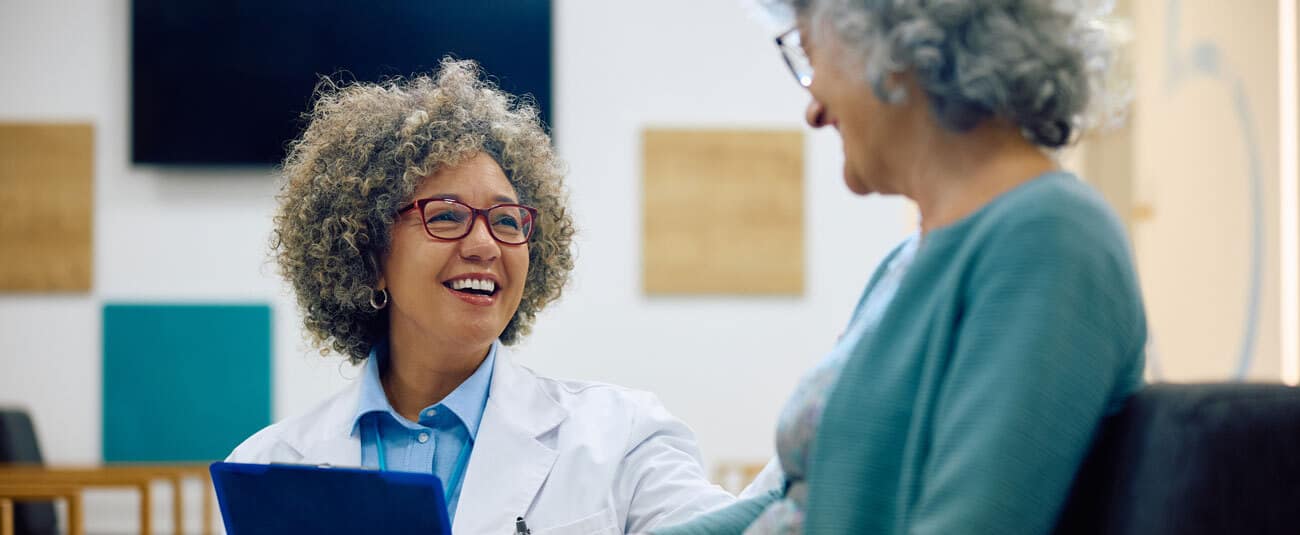 happy-female-doctor-communicating-with-senior-woman