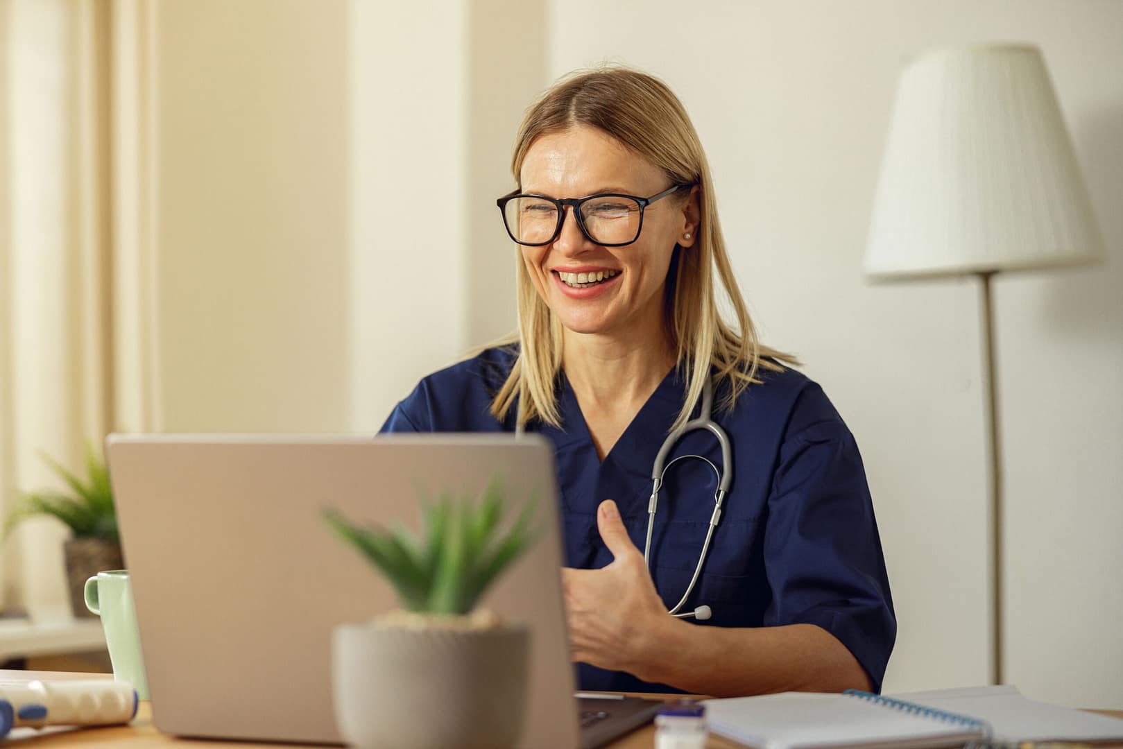 Female doctor talking with colleagues through a video call with a laptop in the consultation